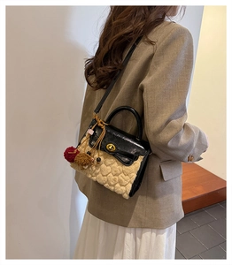 Detail of lamb wool mini bag with gold twist lock and heart quilted texture