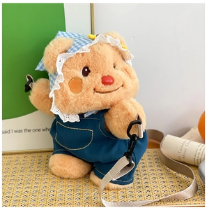 Detail of cute plush bear backpack with blue denim overalls and beige strap on mat