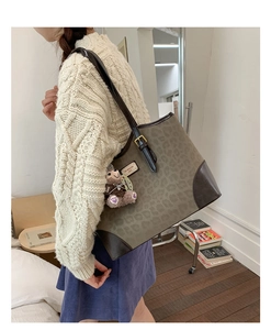 Dettaglio della borsa tote vintage leopardata con finiture in pelle e ciondolo orso