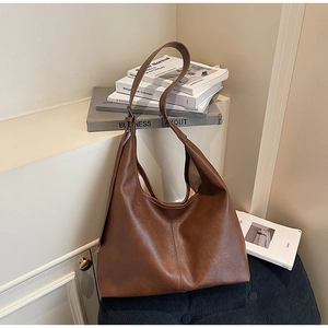 Macro detail of dark brown faux leather tote with textured finish and vertical stitching