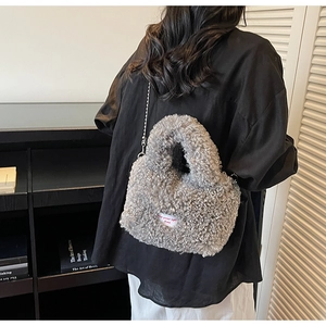 Dettaglio borsa peluche grigia con tracolla a catena e logo spirit free ricamato
