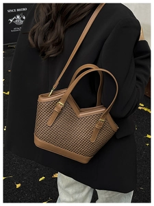 Detailed view of brown woven tote bag with V-shaped edge and adjustable metal buckle