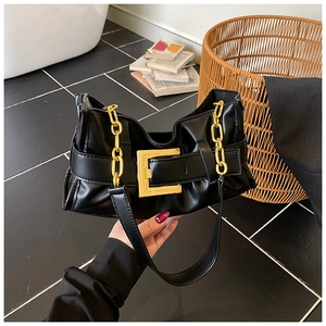 Detail of black pleated shoulder bag featuring chunky gold chain and square buckle