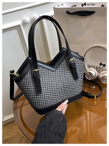 Detail of black and grey woven tote bag featuring gold hardware and leather straps