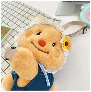 Detail of yellow plush bear crossbody bag with denim overalls and sunflower lace hat