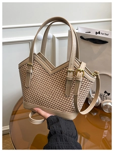 Macro view of woven textured tote bag with premium leather handles and gold metal hardware
