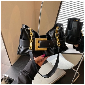 Detail of black pleated shoulder bag with oversized gold square buckle and chain strap