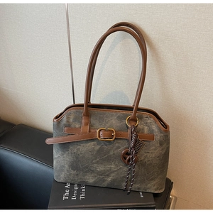 Detail der Vintage Schultertasche in Grau mit braunen Lederriemen und Metallschnallen