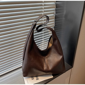 Detail of a dark brown hobo bag showing high-quality leather texture and middle seam line