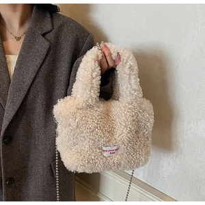 Dettaglio del morbido tessuto peluche beige effetto lana d'agnello con etichetta rossa