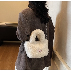 Dettaglio della borsa a secchiello bianca in peluche con catena a sfere e etichetta
