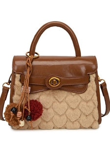 Beige faux fur handbag with heart quilting and brown leather trim on white background