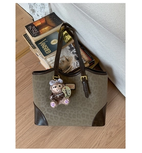 Dettaglio della borsa tote leopardata con finiture in pelle e ciondolo ShellieMay
