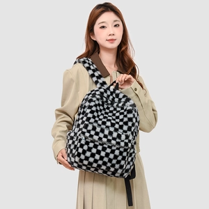 Detail of checkered plush backpack texture with front zipper pocket on model