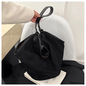 Close-up of black suede tote bag with leather handle showing premium texture and large capacity
