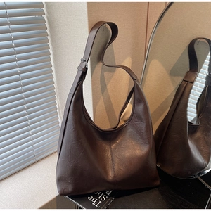 Detail of deep brown hobo bag with adjustable wide strap and vintage leather texture
