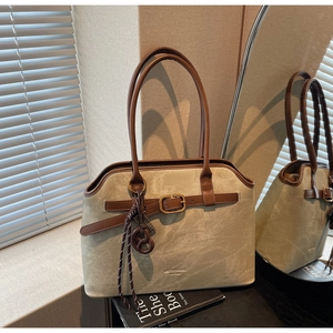Detail der khakifarbenen Frosted-Tote-Bag mit braunem Ledergriff und Metallschnalle