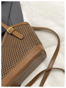 Detail of retro brown woven texture leather bag with gold buckle and stitching