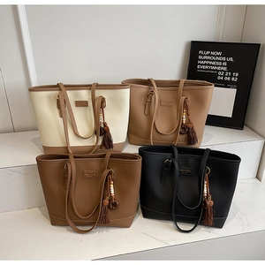 Detail view of large capacity tote bags in four colors with tassel charms