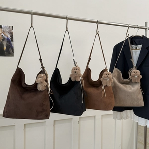 Vue détaillée de grands sacs hobo en daim en quatre couleurs avec pendentifs oursons