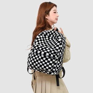 Detail of plush black and white checkerboard backpack with soft faux fur texture