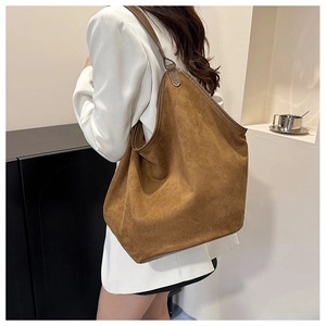 Detail of a large brown suede tote bag featuring premium matte finish and sleek dark piping