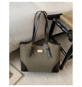 Dettaglio della borsa tote vintage leopardata con finiture in pelle e placca in metallo oro