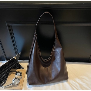 Macro shot of dark brown PU leather hobo bag with vintage texture and wide shoulder strap
