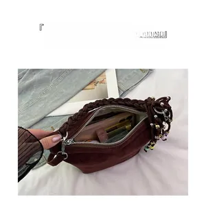 Detail view of brown suede bucket bag featuring woven handle and colorful beaded tassels