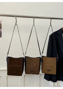Détail de trois sacs seaux rétro en patchwork avec imprimé léopard et daim marron