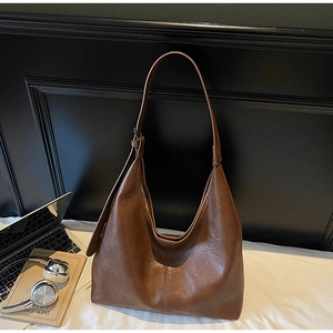 Macro detail of dark brown hobo shoulder bag with adjustable strap and visible stitching