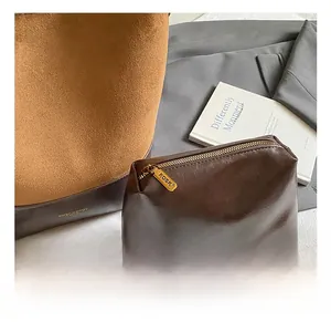Detail of suede bucket bag and leather pouch with KOSK logo zipper in lazy style