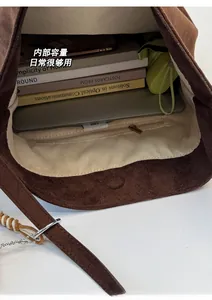 Intérieur spacieux d'un sac cabas vintage en daim marron foncé avec poche zippée pratique