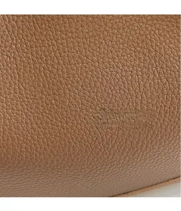 Macro view of brown lychee grain leather texture on a high-quality tote bag
