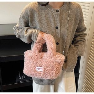 Dettaglio della borsa a secchiello in peluche rosa con etichetta in tessuto e manico morbido