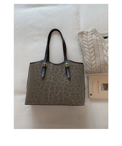 Dettaglio della borsa tote leopardata con manici in pelle marrone e fibbie dorate