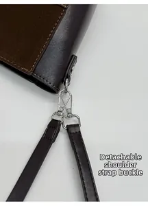 Détail du fermoir mousqueton argenté et des coutures sur le sac seau en daim marron