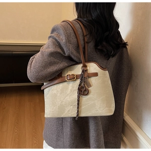Nahaufnahme der Vintage-Beige-Tote-Tasche mit braunen Lederriemen und Metallschnalle