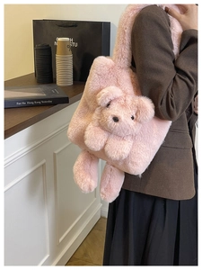 Détail latéral d'un sac à bandoulière en fausse fourrure rose avec un décor d'ours