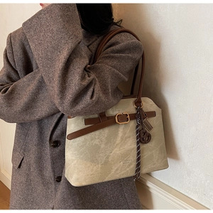 Detail der Vintage-Einkaufstasche mit Marmormuster, Ledergriff und Quastenanhänger