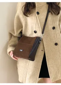Détail d'un sac bandoulière en cuir marron assorti à un manteau en laine beige pour l'automne