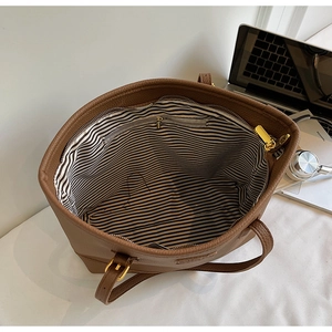 Detail of coffee brown tote bag showing spacious interior with striped lining and gold zipper