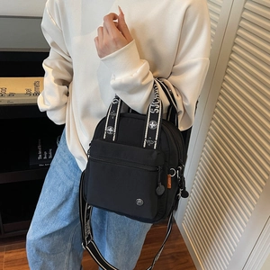 Sac à bandoulière polyvalent en nylon noir avec sangle large stylée et poche avant zippée