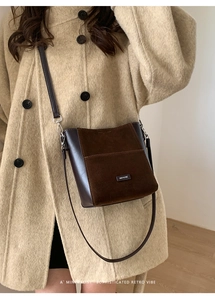 Sac seau marron foncé avec étiquette NO FILTER porté sur un manteau en laine beige