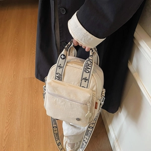 Sac bandoulière beige chic avec sangle large imprimée et plusieurs poches zippées pratiques