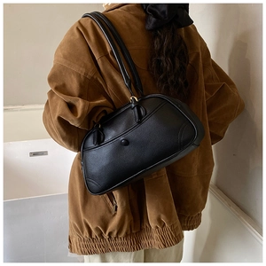 Detail of vintage black bowling bag showing pebbled leather texture and gold hardware