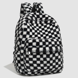 Detail view of plush black and white checkerboard backpack with soft faux fur texture