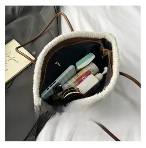 Vue intérieure d'un sac cabas tressé marron avec bordure en fourrure et rangements