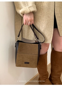 Detail of the bucket bag's matte suede and brown leather texture with NO FILTER plaque