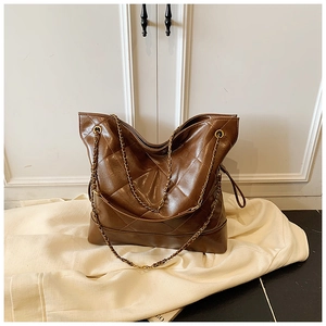 Close-up of brown quilted hobo bag featuring glossy finish and gold metal chain strap